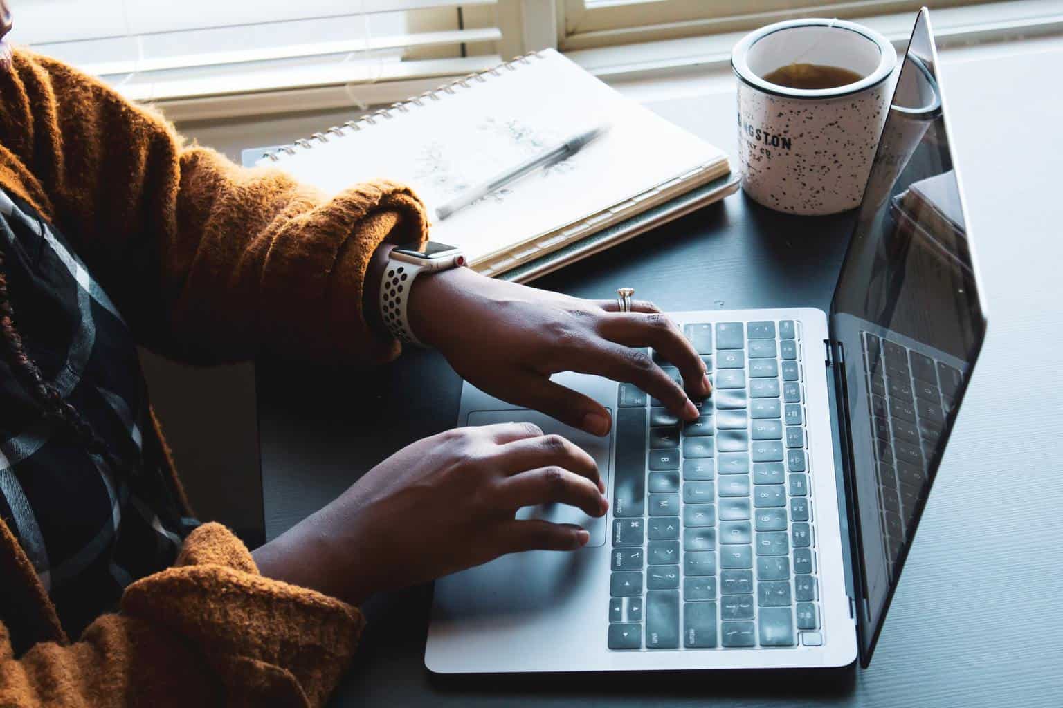 Typing on laptop with coffee