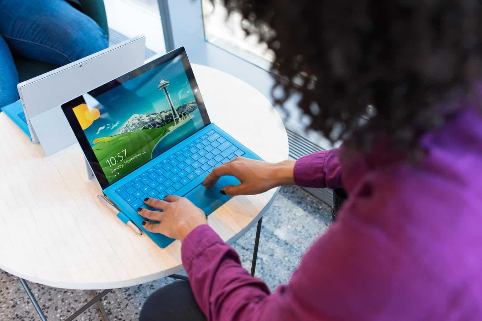 Woman typing on blue laptop